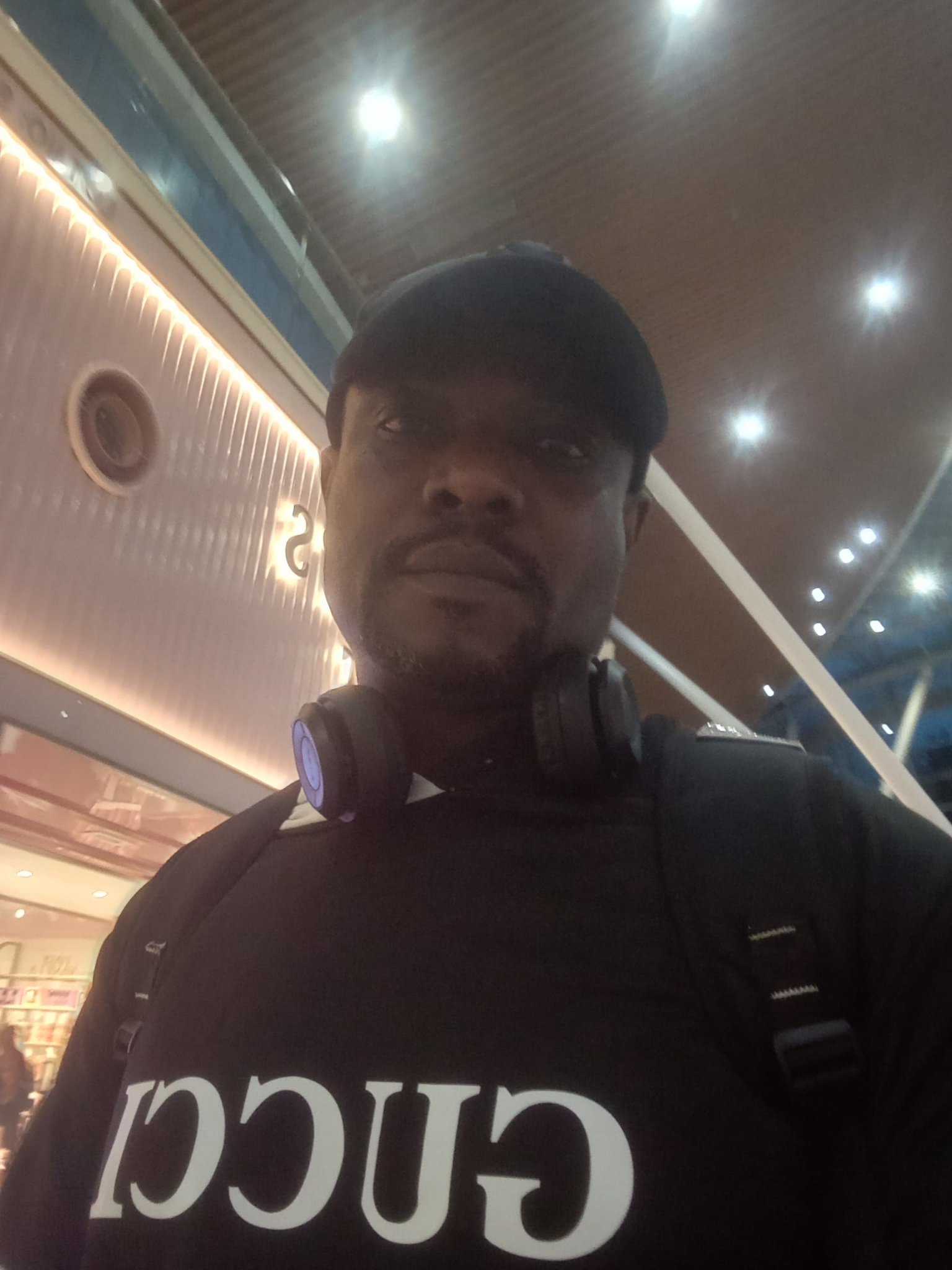 Indoors, black shirt and cap
