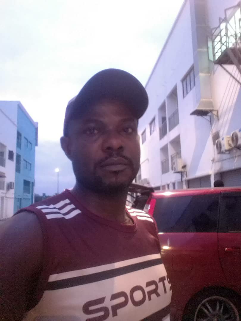 Outdoors, beside a red car