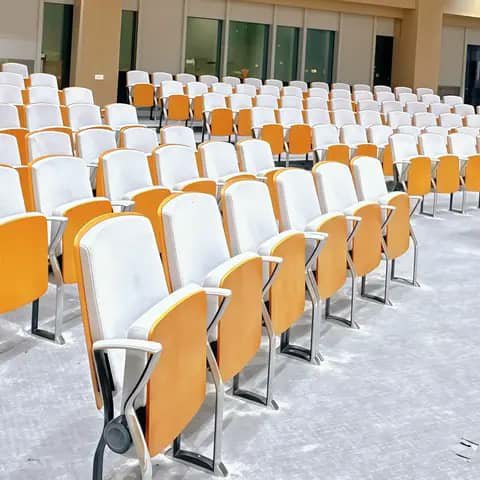 Rows of orange and white auditorium chairs