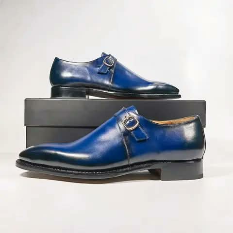 Blue monk strap shoes, one pair resting on a shoebox.