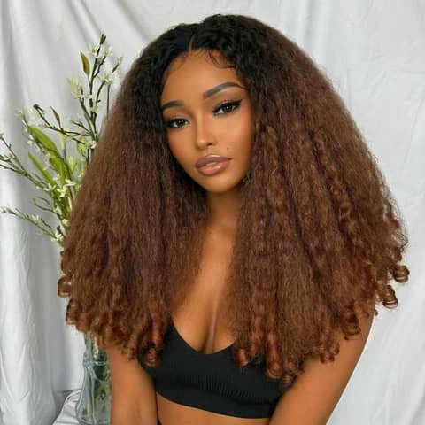 A woman wearing a voluminous curly wig with brown ombre colouring.