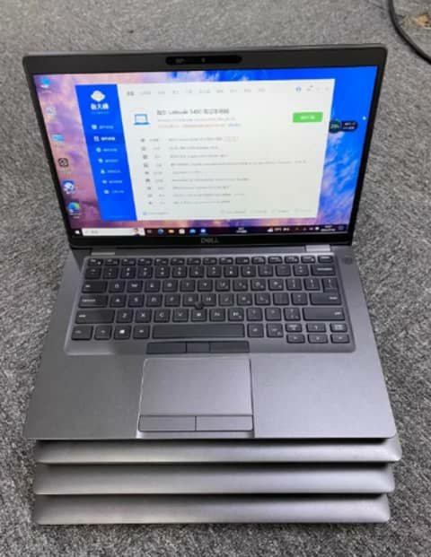 Dell Latitude 5400 open on a stack of laptops
