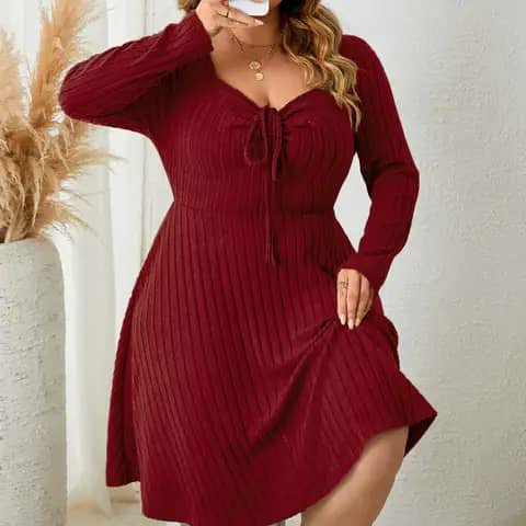 A woman wearing a burgundy ribbed knit dress with a front tie at the neckline.