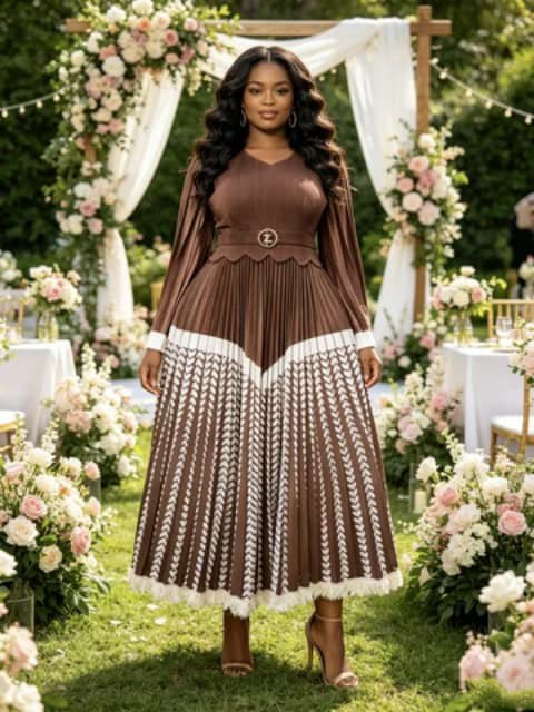 A woman wearing a long brown pleated dress with a white zigzag panel and a belt, at an outdoor wedding arch.