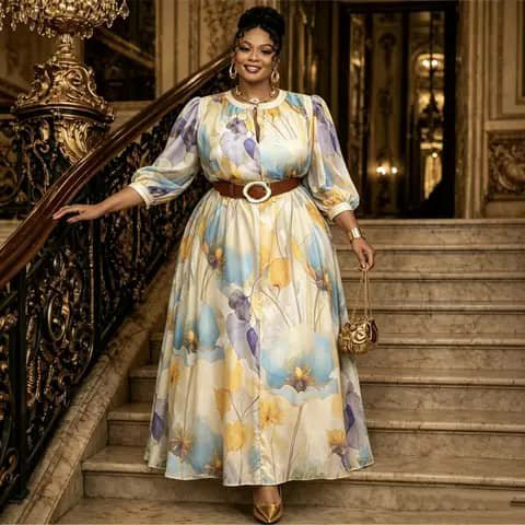 A woman wearing a long floral dress with a brown belt, standing on stairs.