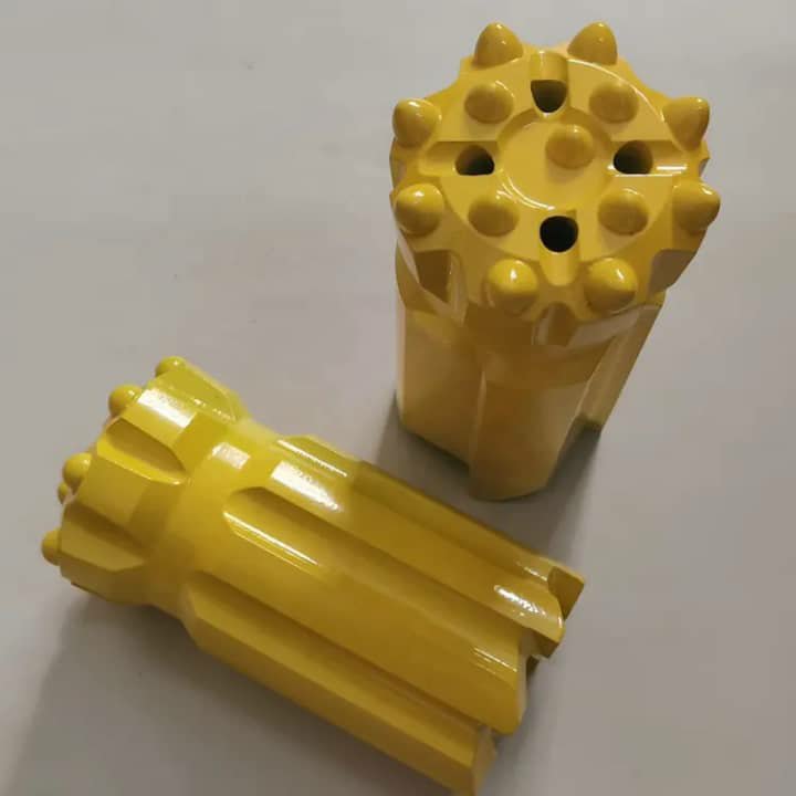 Two yellow drill bits on a grey background.