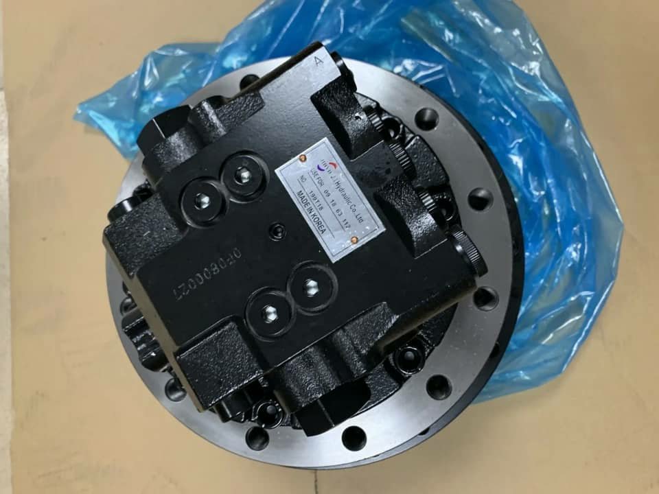 A black final drive motor with a round steel flange, on blue plastic.