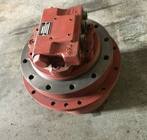 A red round final drive motor with a bolted flange, on a concrete floor.
