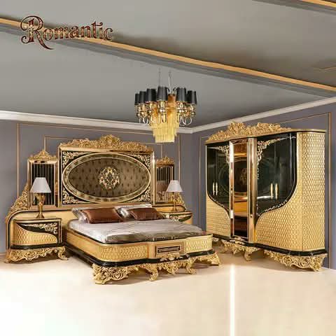 A gold ornate bedroom set — bed, wardrobes and side tables.