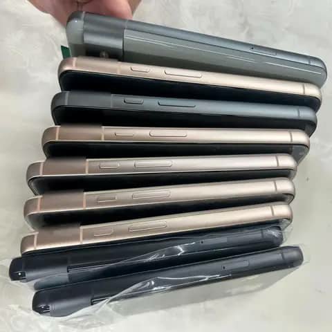 Google Pixel phones stacked, shown from the side, black gold and pink