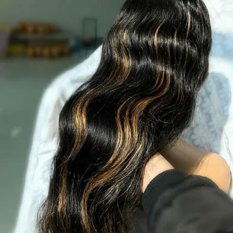 Long wavy black hair with caramel highlights, shown from behind.
