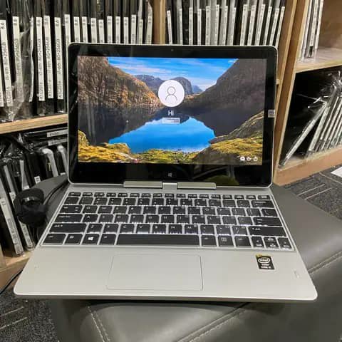 Silver HP convertible laptop open on a desk, login screen