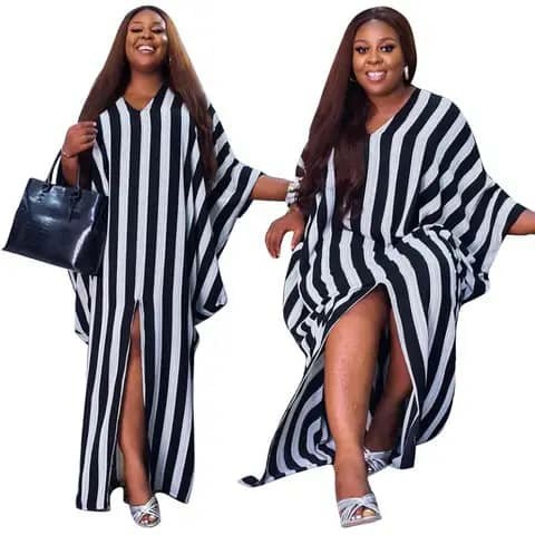 A woman wearing a long black-and-white striped kaftan with side slits.