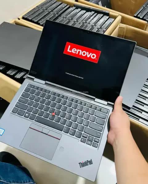 Lenovo ThinkPad laptop held open, switching on