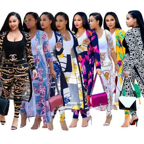 Six women wearing long open patterned cardigans over dark tops, carrying handbags.