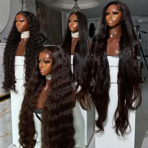 Four very long dark wigs in straight, wavy and curly styles on mannequin heads.