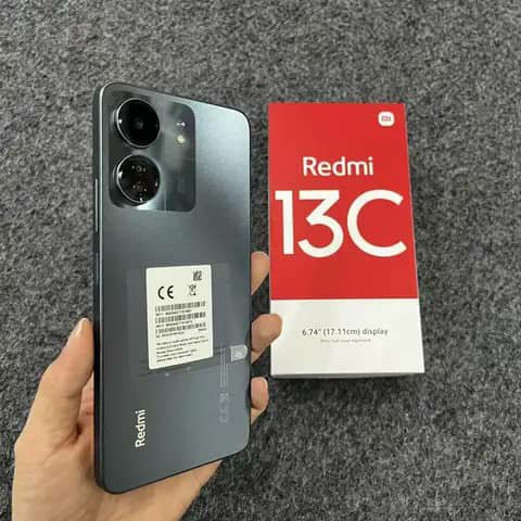 Redmi 13C held up beside its box