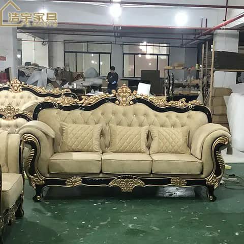 Ornate beige sofa with gold and black frame