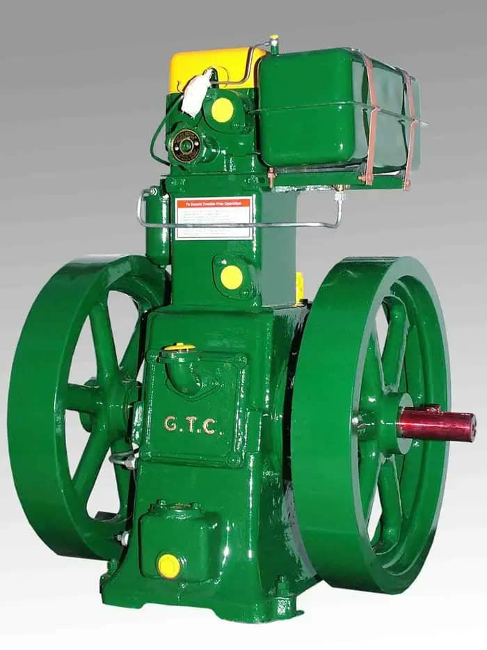 A green stationary engine with G.T.C. lettering, twin flywheels and a red shaft.
