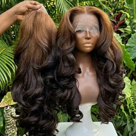 A long wavy brown ombre wig shown loose and on a mannequin head outdoors.