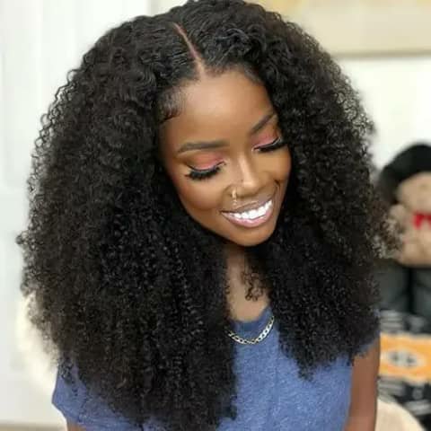 A woman wearing a voluminous dark afro-curly wig.
