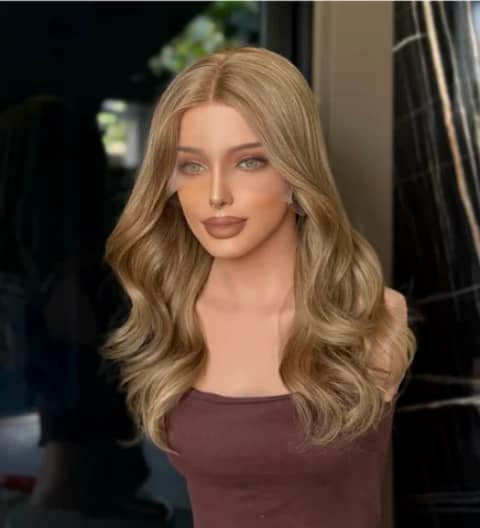 A mannequin head wearing a long wavy ash-blonde wig.